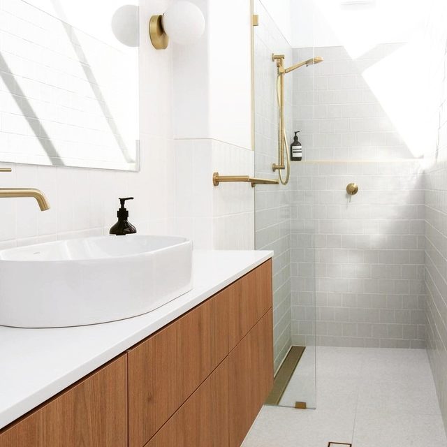 Bathroom with white tile walk-in shower and a walnut vanity