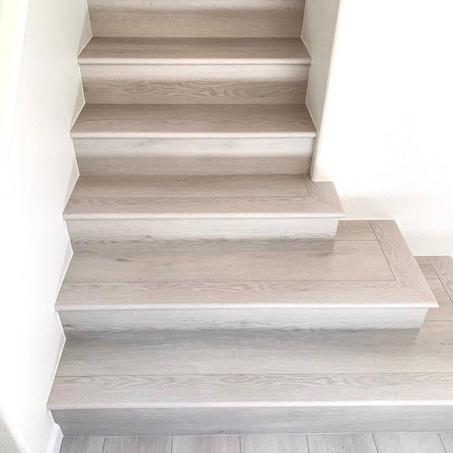 Straight staircase with light vinyl plank treads and white risers